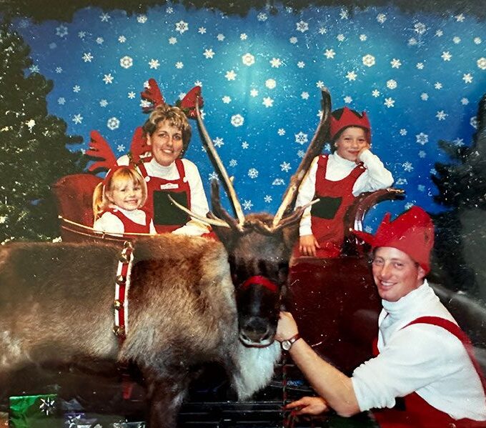 Family Christmas photo with reindeer and Christmas tree